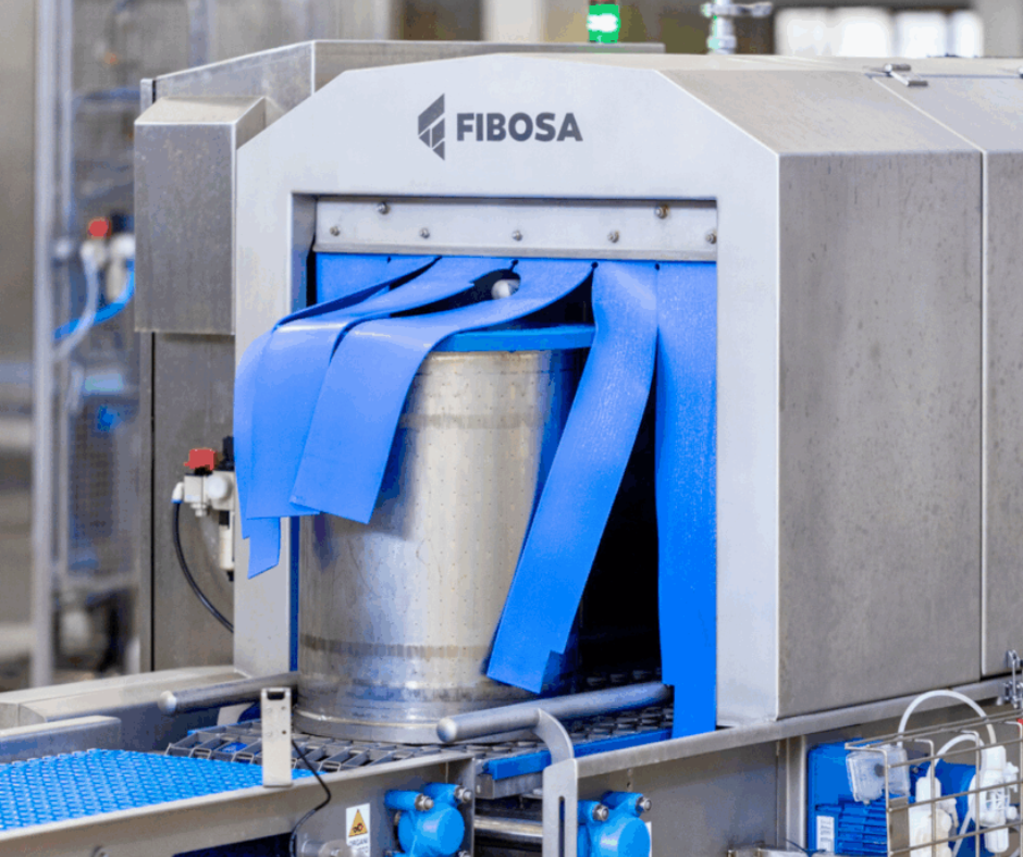 Túnel de lavado industrial FIBOSA para moldes de queso, fabricado en acero inoxidable, con cortinas flexibles azules y sistema automático de limpieza en línea de producción quesera